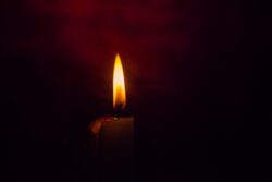 VELA ENCENDIDA DENTRO DE LA OSCURIDAD