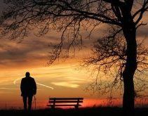 Imagen de un atardecer y la figura de un anciano en medio.